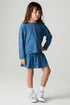Full body front view of a girl wearing the Chaser Tiny Hearts Girls Skirt on a neutral background with matching shirt