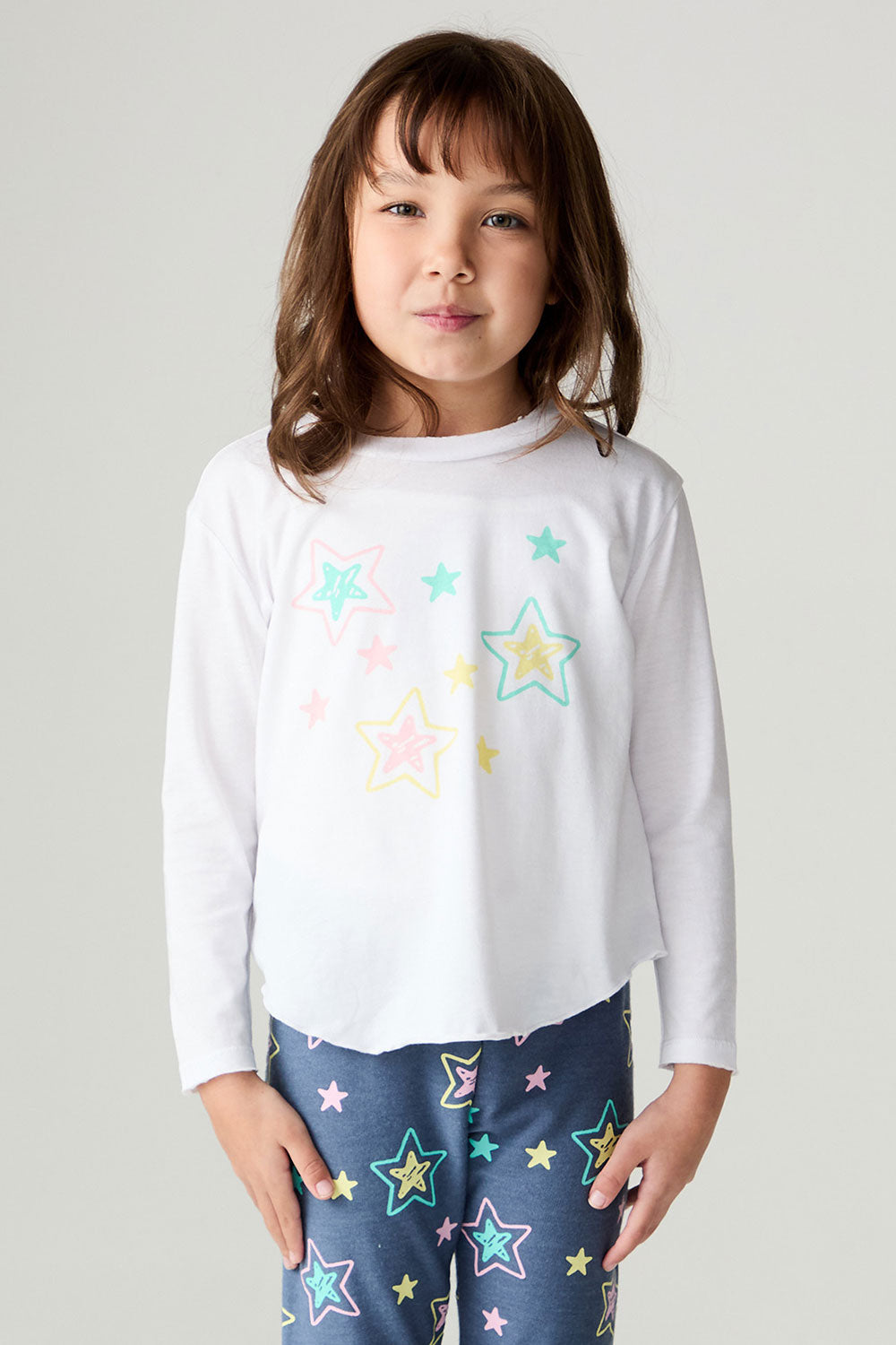 Front view of a girl wearing the Chaser Under The Stars Girls Tee on a neutral background with star pants