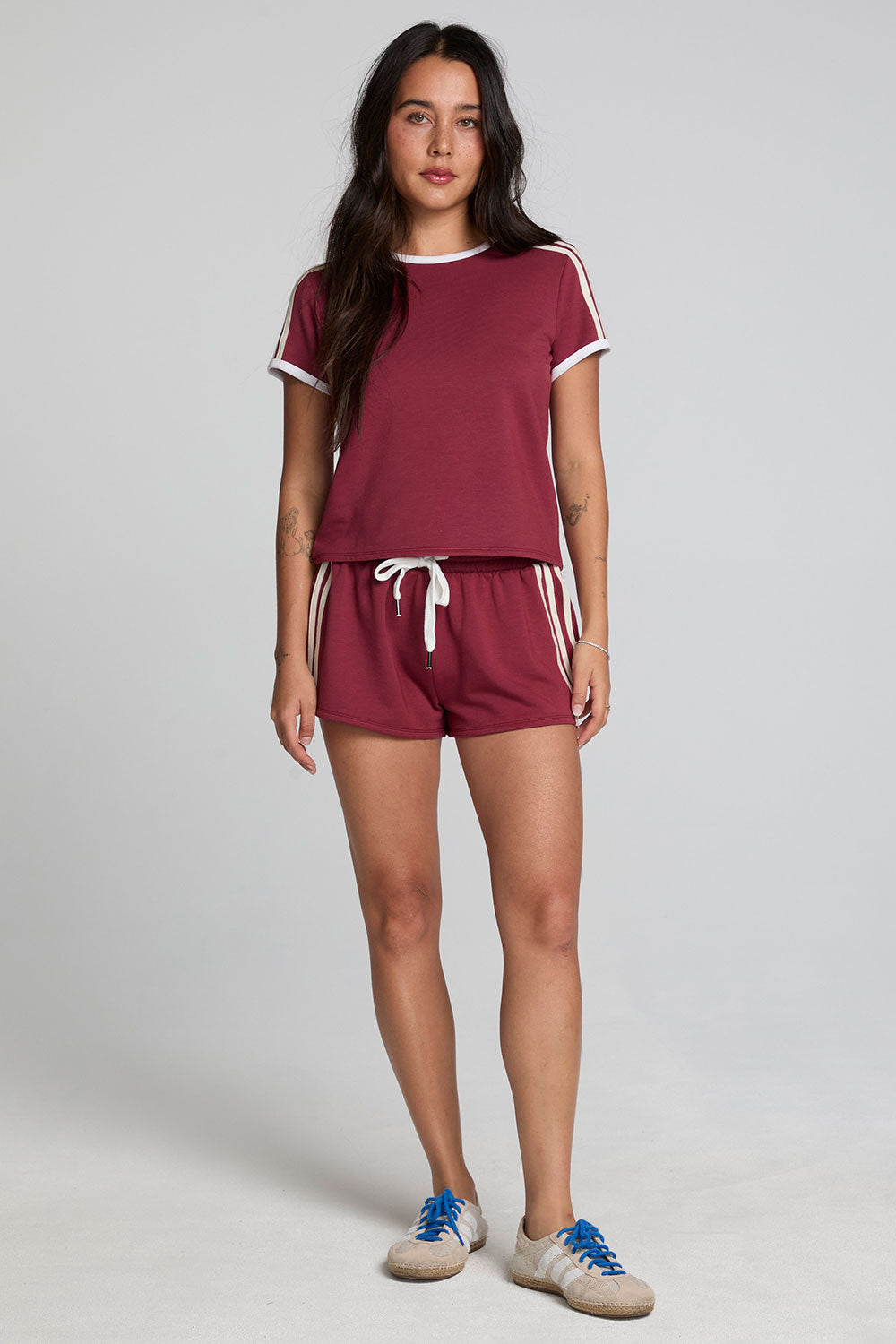 A full body front view of a woman wearing the Chaser Urban Burnt Red Tee on a neutral background