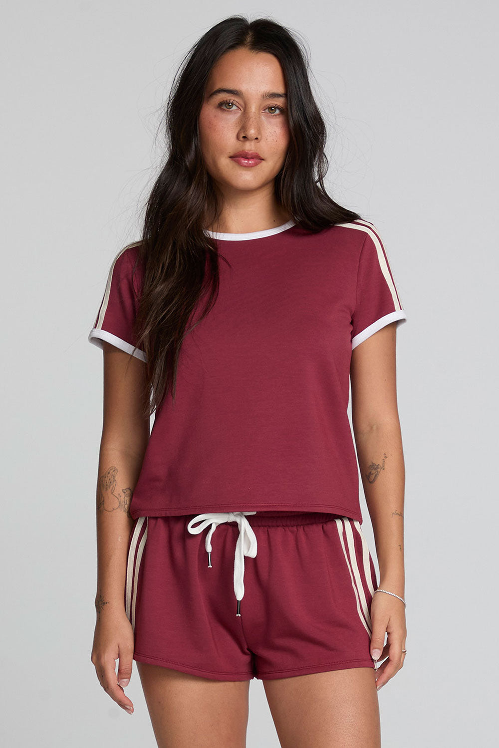 Front view of a woman wearing the Chaser Urban Burnt Red Tee on a neutral background with matching shorts
