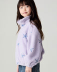 Side view of a girl wearing the Chaser Varsity Stars Girls Varsity Jacket on a neutral background with jeans looking at camera