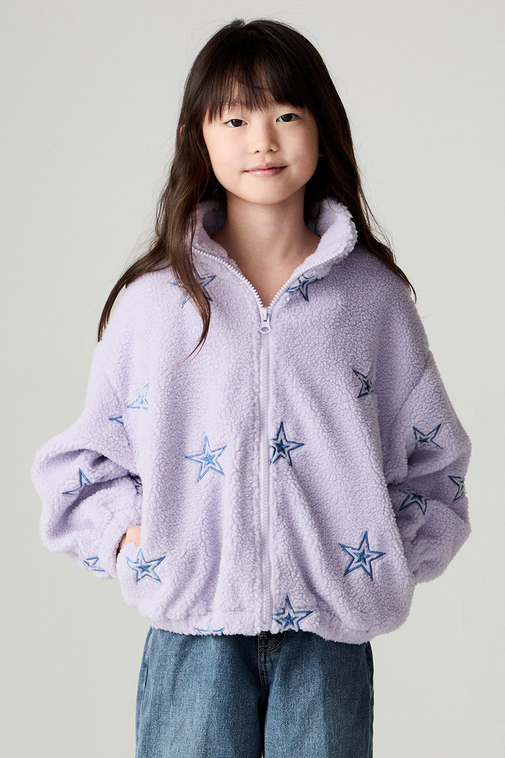Front view of a girl wearing the Chaser Varsity Stars Girls Varsity Jacket on a neutral background looking at camera