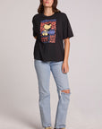 Full body front view of a woman wearing the Chaser  Woodstock Bird on Guitar Tee on a neutral background