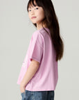 Back view of a girl wearing the Chaser Yee Haw Girls Tee and jeans on a neutral background