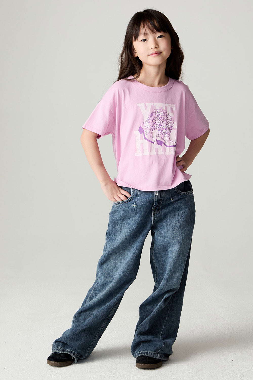 A full body front view of a girl wearing the Chaser Yee Haw Girls Tee on a neutral background