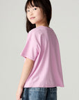 Back view of a girl wearing the Chaser Yee Haw Girls Tee and jeans on a neutral background looking over one shoulder