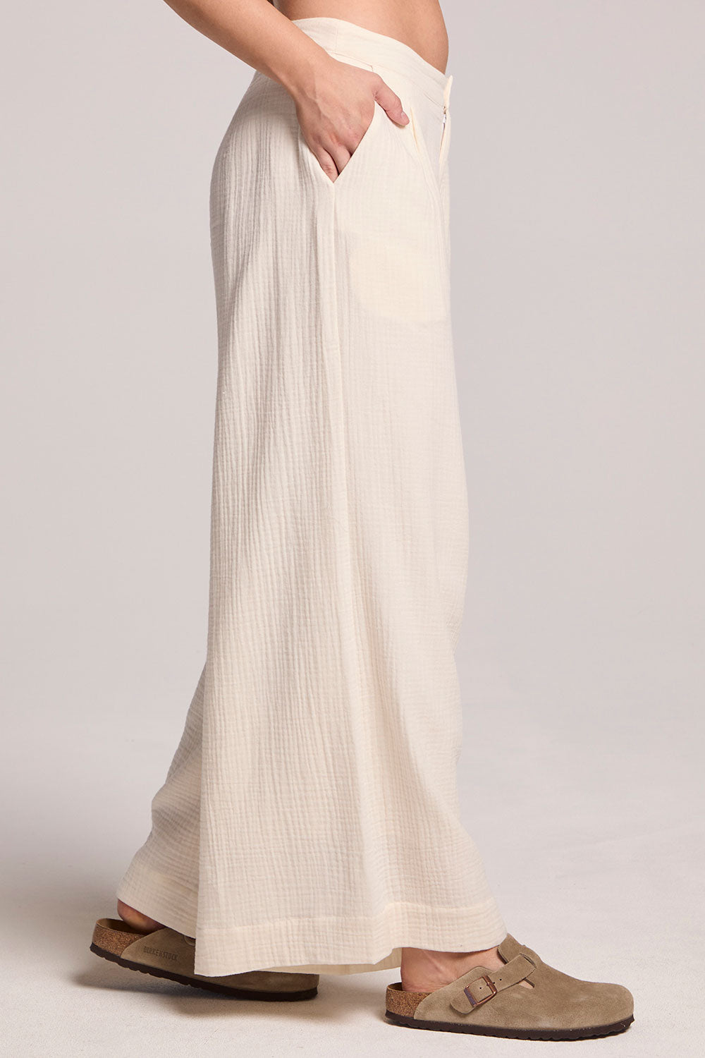 Side view of a woman wearing the Chaser Coconut Milk Campaniaa Trousers on a neutral background 