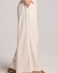 Side view of a woman wearing the Chaser Coconut Milk Campaniaa Trousers on a neutral background 