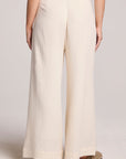 Back view of a woman wearing the Chaser Coconut Milk Campaniaa Trousers on a neutral background 