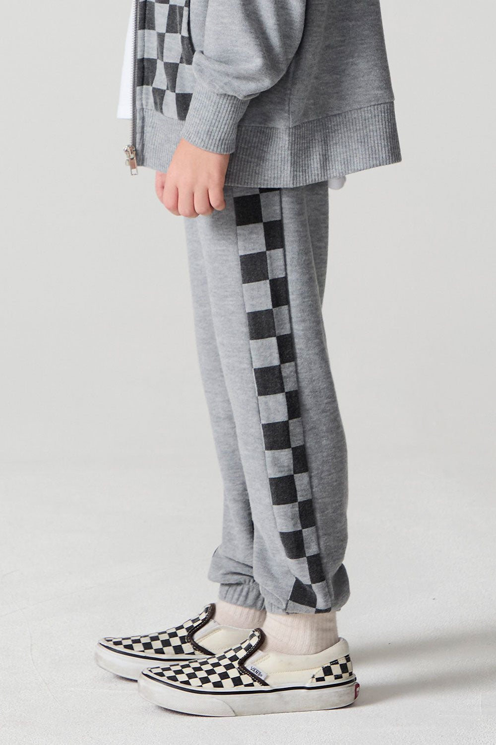 Side view of a boy wearing the Chaser Color Block Heather Grey Barrel Leg Pants on a neutral background