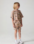 Full body side view of a boy wearing the Chaser Construction Days Shorts on a neutral background