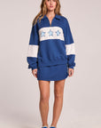 Full body front view of a woman wearing the Chaser  Courtside Skort and matching top on a neutral background