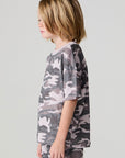 Side view of a boy wearing the Chaser Dusty Camo Tee  on a neutral background