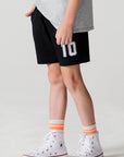 Side angle view of a boy wearing the Chaser Go Team Shorts on a neutral background

