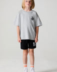 Full body front view of a boy wearing the Chaser Go Team Tee  on a neutral background
