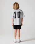 A full body back view of a boy wearing the Chaser Go Team Tee  on a neutral background
