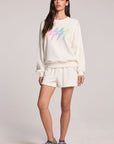 Front view of a woman wearing the Chaser Gradient Bolt Pullover and sneakers on a neutral background