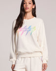 Front view of a woman wearing the Chaser Gradient Bolt Pullover and  shorts on a neutral background
