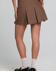 Back view of a woman wearing the Chaser Ivy Choco Check Skort on a neutral background with black loafer shoes