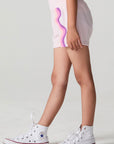 Side angle view of a girl wearing the Chaser Jade Begonia Shorts on a neutral background
