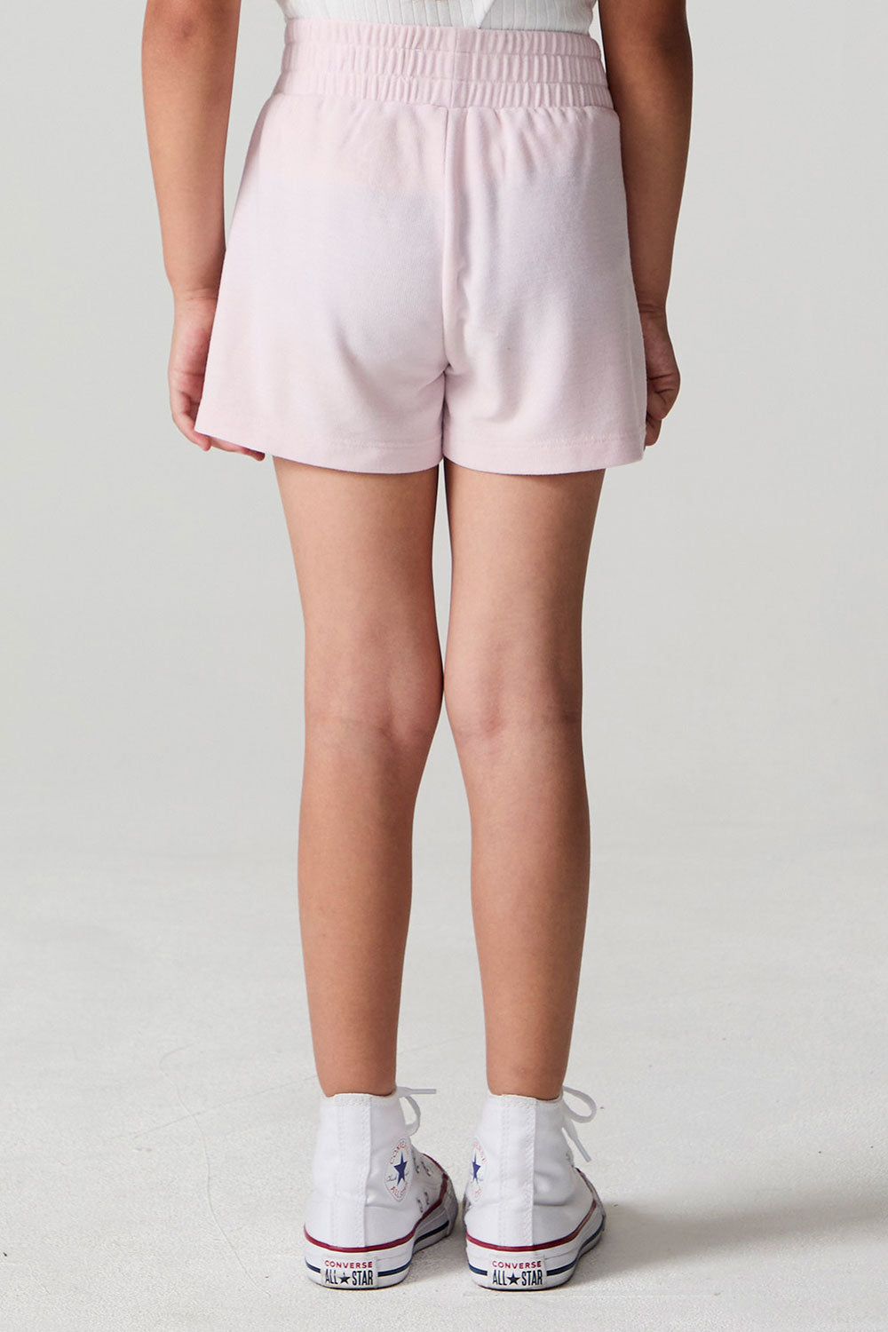 Back view of a girl wearing the Chaser Jade Begonia Shorts on a neutral background
