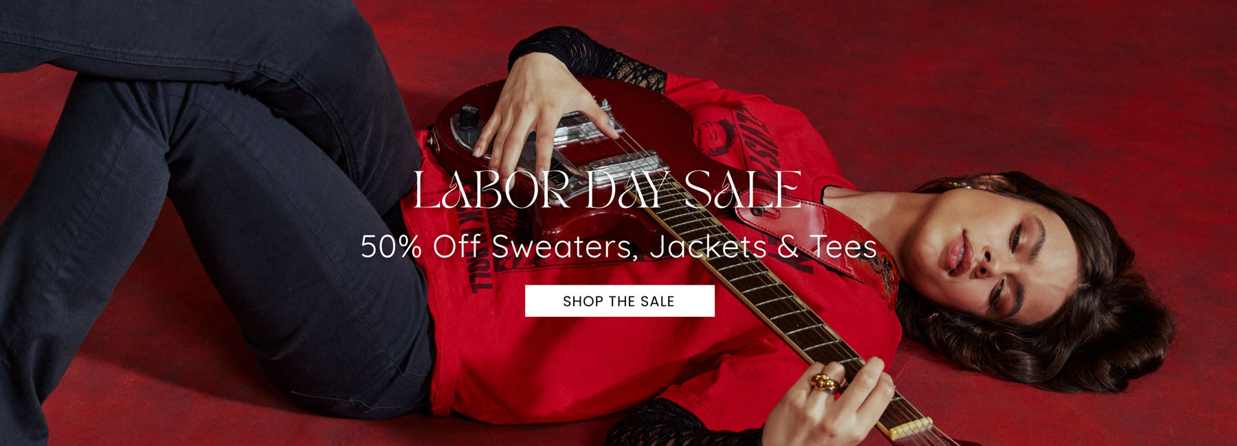 Person in red shirt playing guitar on a red background with Labor Day sale text overlay.