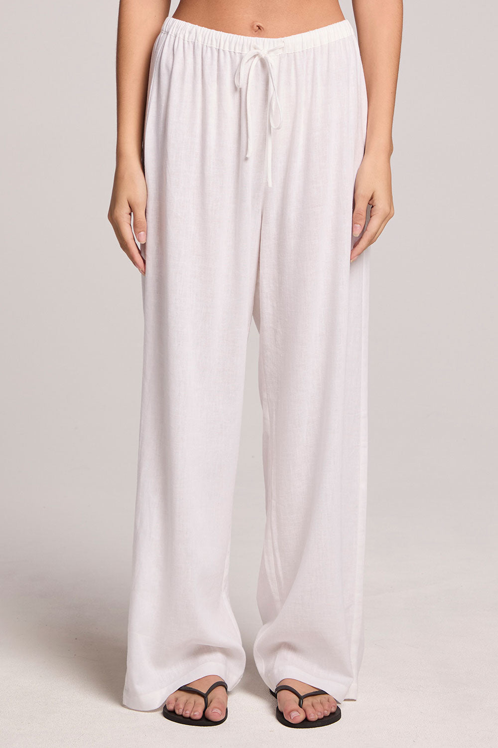  A front view of a woman wearing the Chaser Lee White Trouser  and shoes on a neutral background
