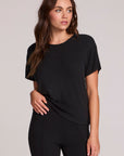 Front view of a woman wearing the Chaser   Leonor Black Tee on a neutral background