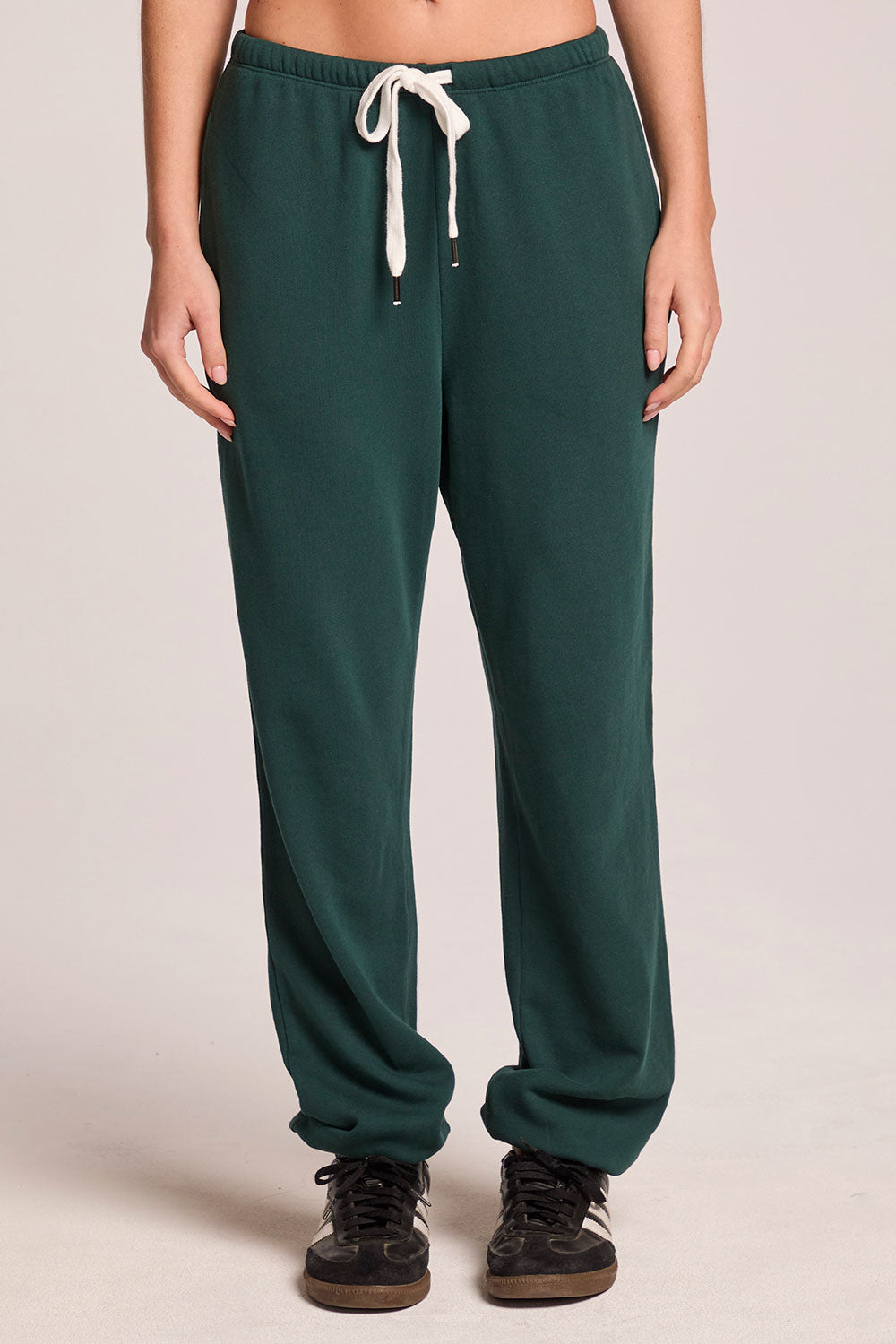 Front view of a woman wearing the Chaser   Manhattan Pine Joggers on a neutral background with hands at her sides

