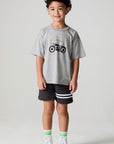 Full body front view of a boy wearing the Chaser  Moto LA Tee on a neutral background