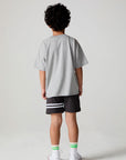 Full body back view of a boy wearing the Chaser  Moto LA Tee on a neutral background