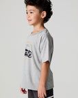 Side angle view of a boy wearing the Chaser  Moto LA Tee on a neutral background