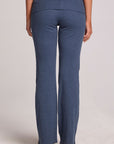 Back view of a woman wearing the Chaser Noorh Dark Denim Pants with arms down at side