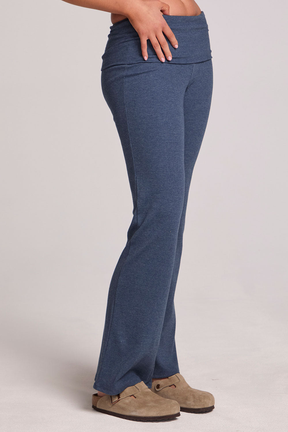 Side angle view of a woman wearing the Chaser Noorh Dark Denim Pants with arms at waist