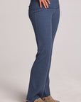 Side angle view of a woman wearing the Chaser Noorh Dark Denim Pants with arms at waist