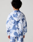 Back view of a boy wearing the Chaser Paxton Mistel Tie Dye Zip Up Hoodie on a neutral background