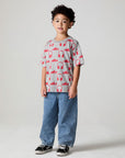 Full body side angle view of a boy wearing the Chaser Sneaks and Headphones Tee on a neutral background