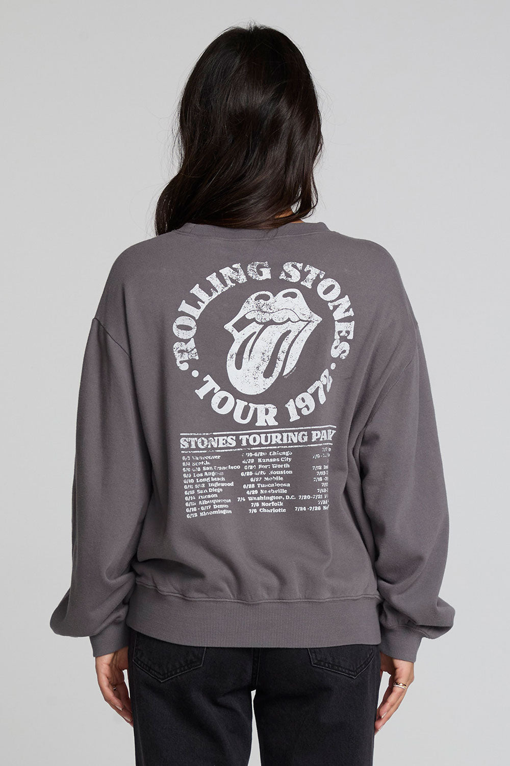 Back view of a woman wearing the Chaser The Rolling Stones 78 Tour Cropped Sweatshirt on a neutral background with pants