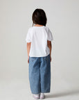 Full body back view of a girl wearing the Chaser Willie Nelson Cowgirl Tee on a neutral background
